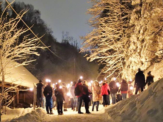 Fackelwandergruppe im Schnee