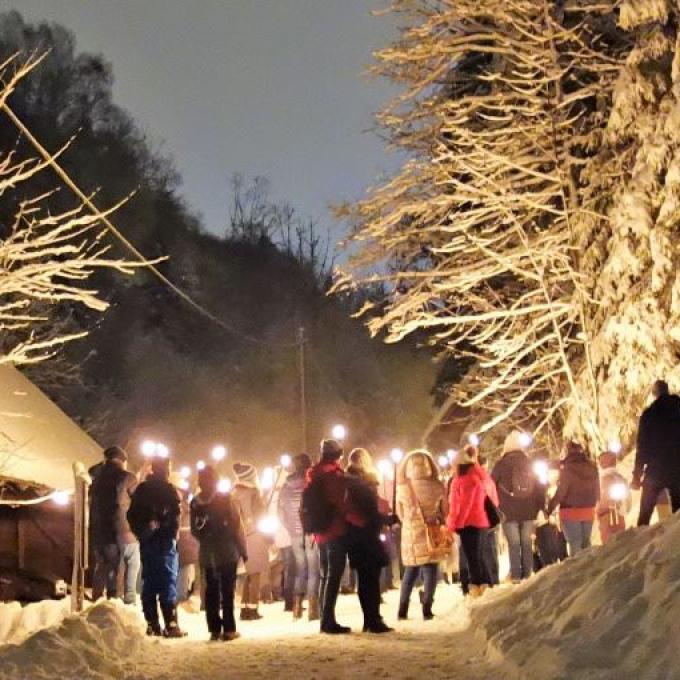 Fackelwandergruppe im Schnee